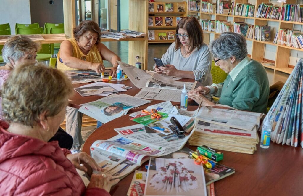 A group of senior women do a craft.