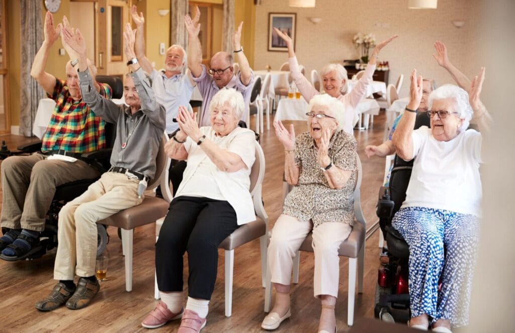 Seniors applaud at a senior living community.