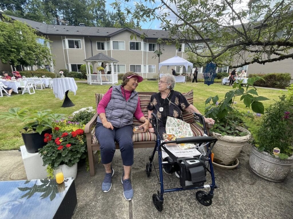 Seniors laugh together outside Overlake Terrace memory care.