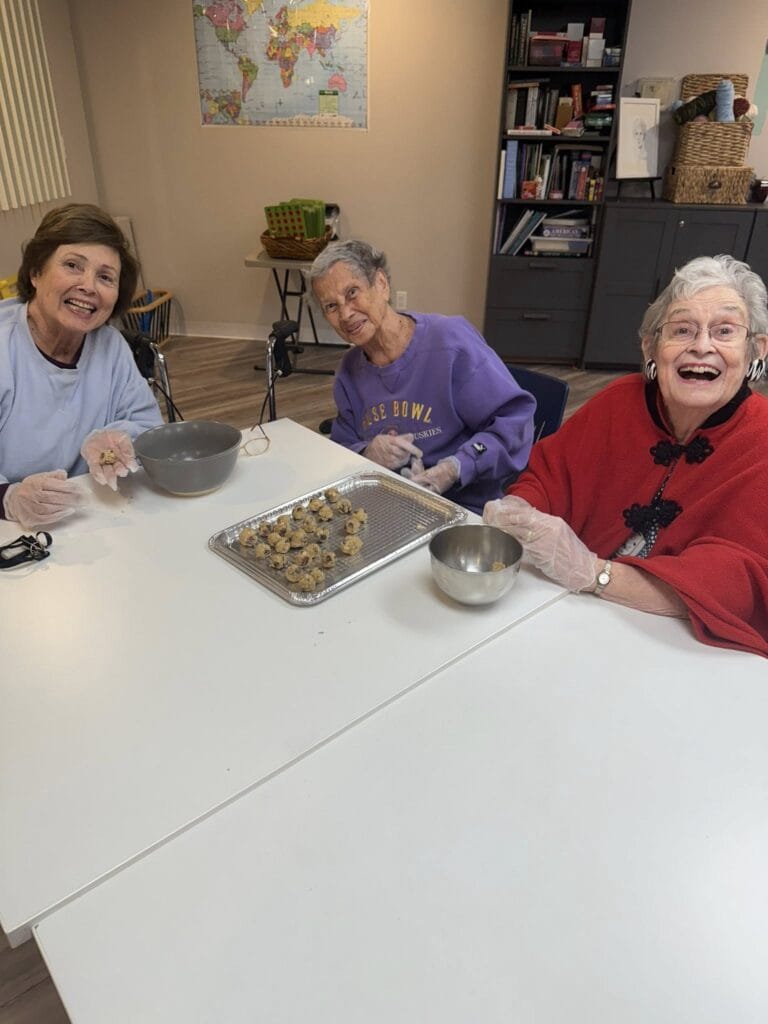 Overlake Terrace Memory Care residents beaming over a tray of unbaked cookie dough.