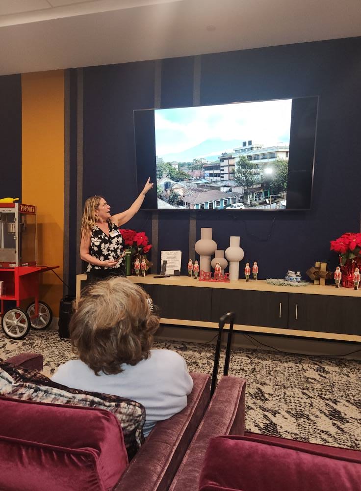 Acoya Cherry Creek staff member showing residents photos from a trip to Africa.
