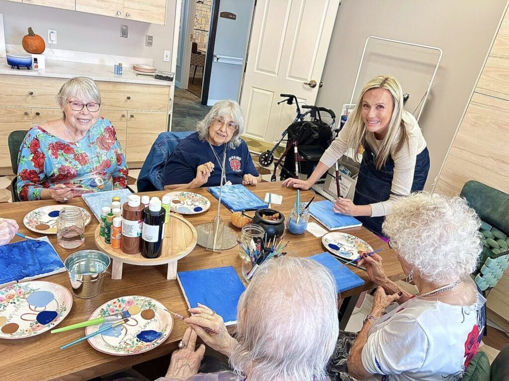 A loving staff member helps Lakewood Reserve assisted living residents with a craft