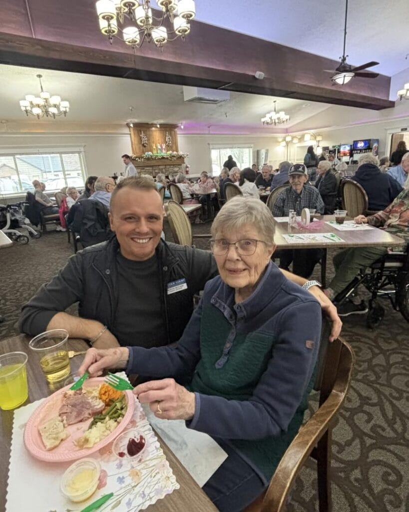 A senior enjoys dinner with a team member in the Lincoln Court dining room